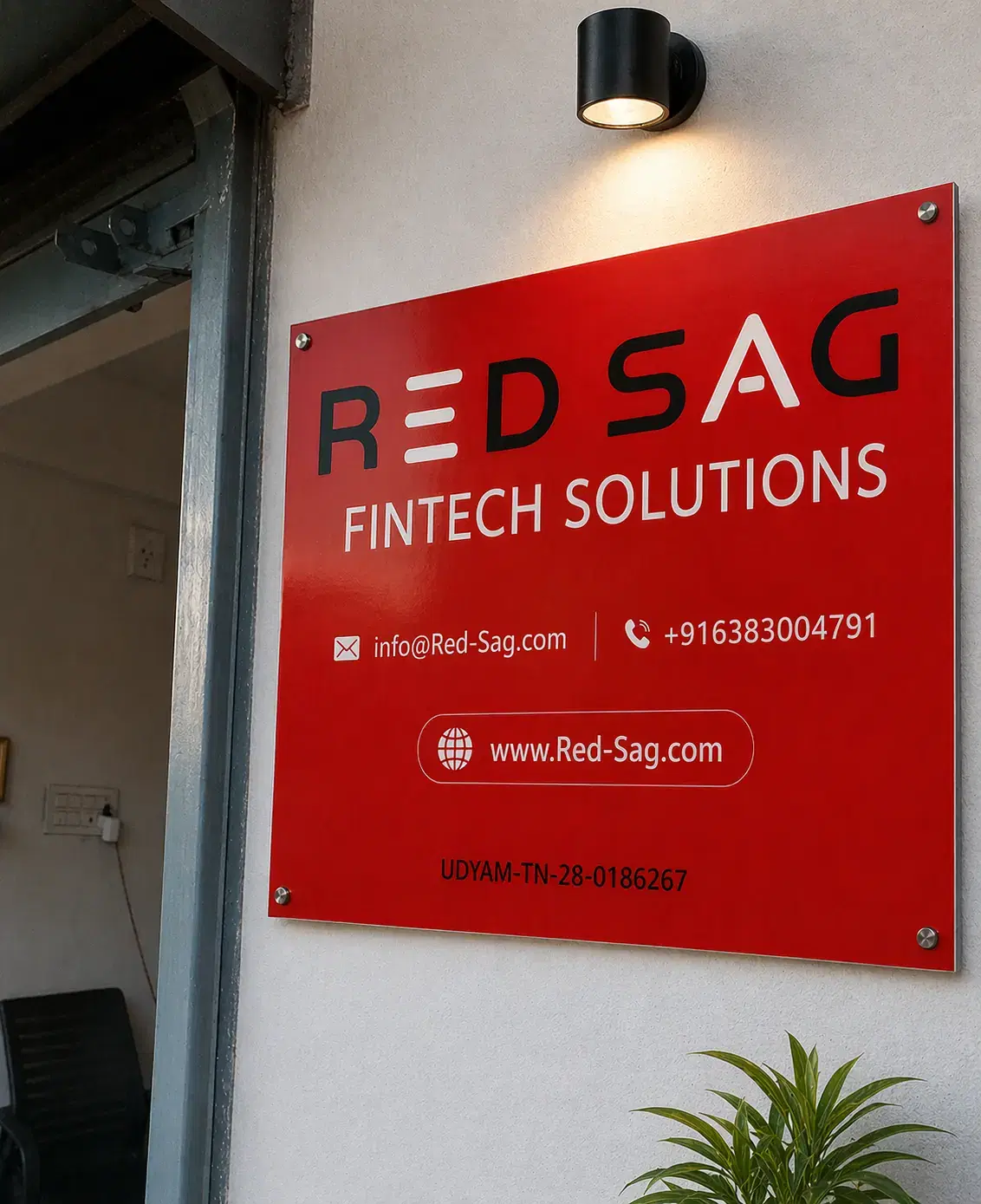 Red signboard at the office entrance reading "RED SAG Fintech Solutions" with our email, phone number, website and Udyam registration number