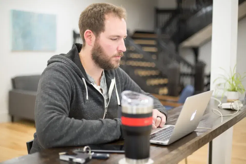 Software developer working on a laptop at a desk, representing outsourced development