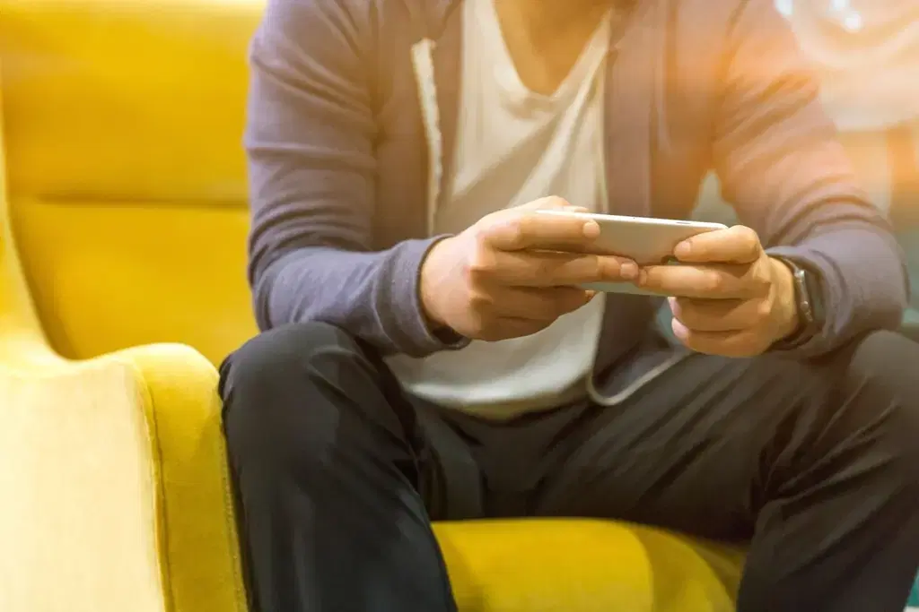 Person holding a smartphone sideways while testing a React Native mobile app