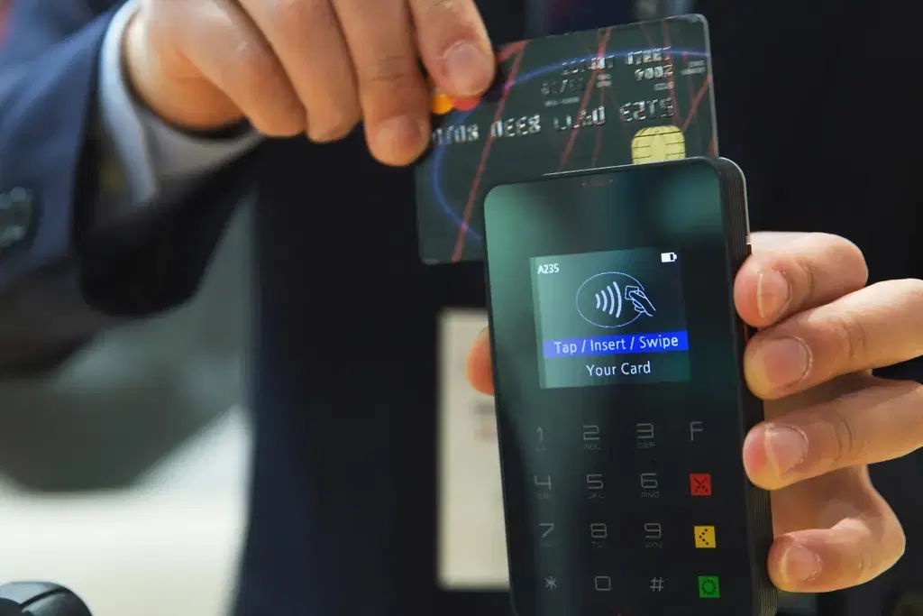 Customer inserting a chip card into a handheld card payment terminal