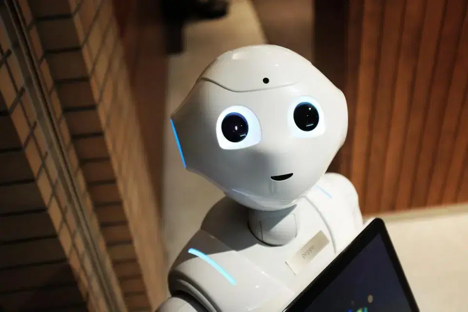 Humanoid service robot holding a tablet, illustrating AI chatbot development cost