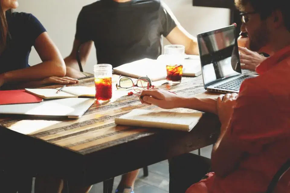 Clients and a software development company discussing a project around a meeting table