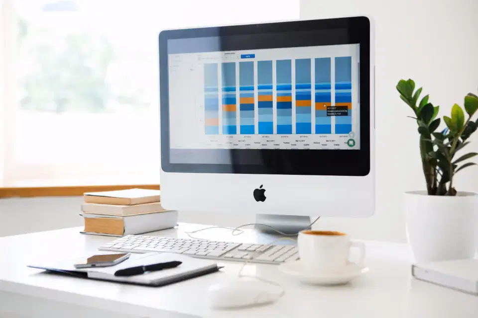 Desktop computer showing a SaaS analytics dashboard on a tidy office desk