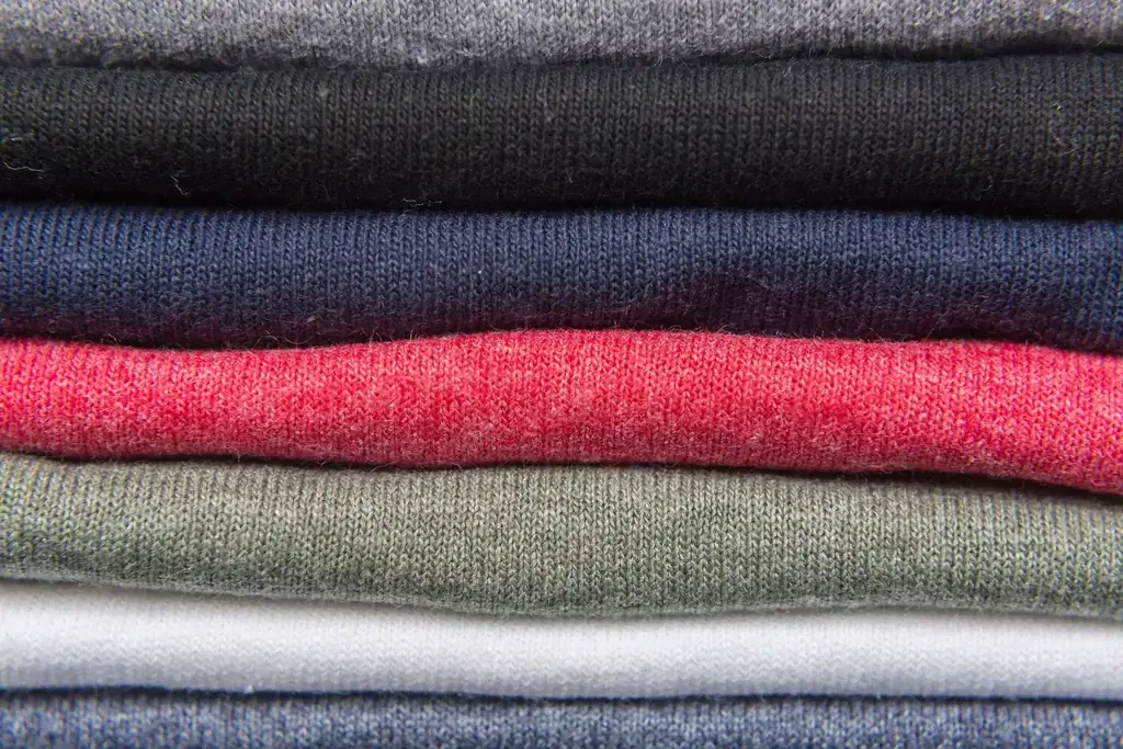 Stack of folded cotton knit T-shirts in different colours, typical of Tiruppur garment exporters