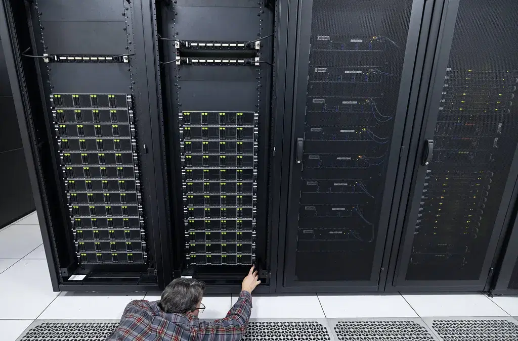 Technician checking server racks in a data centre as part of website maintenance