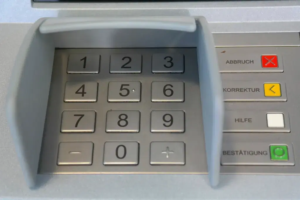 Close-up of an ATM keypad with number keys and confirm and cancel buttons