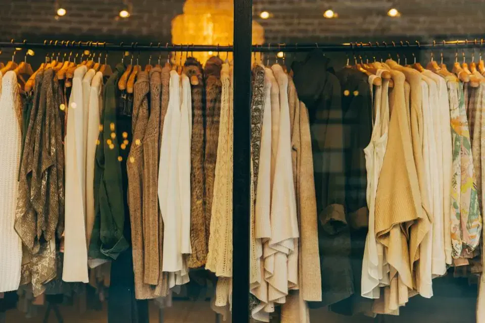 Racks of shirts and jackets on hangers inside a clothing retail store