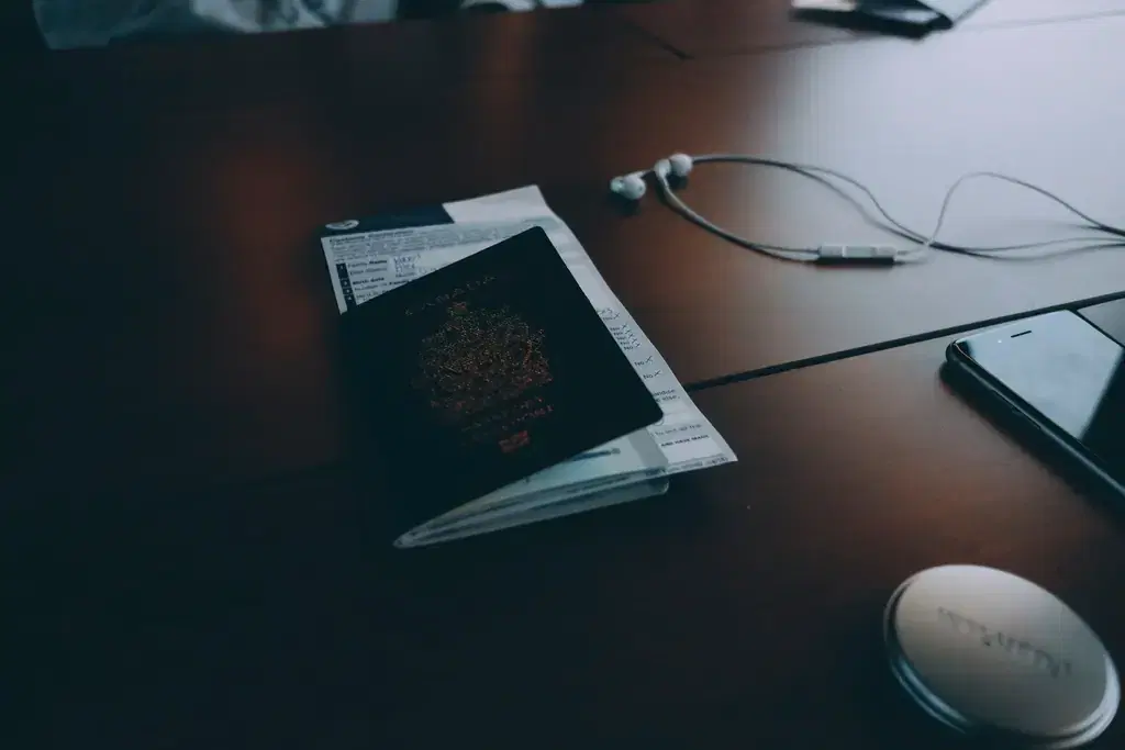 Passport and identity documents on a desk next to a smartphone, ready for KYC verification