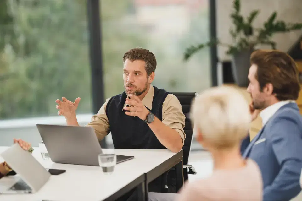 Product team discussing a SaaS roadmap around a laptop in a bright office